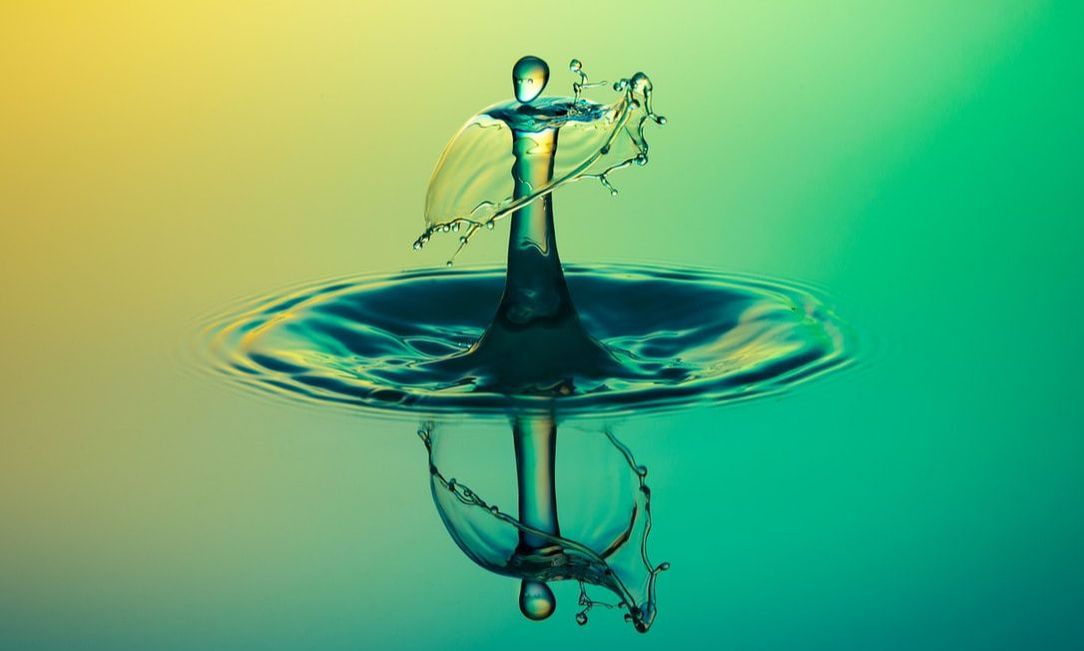 Magnified still shot of splash caused by a drop of water falling into water and its reflection